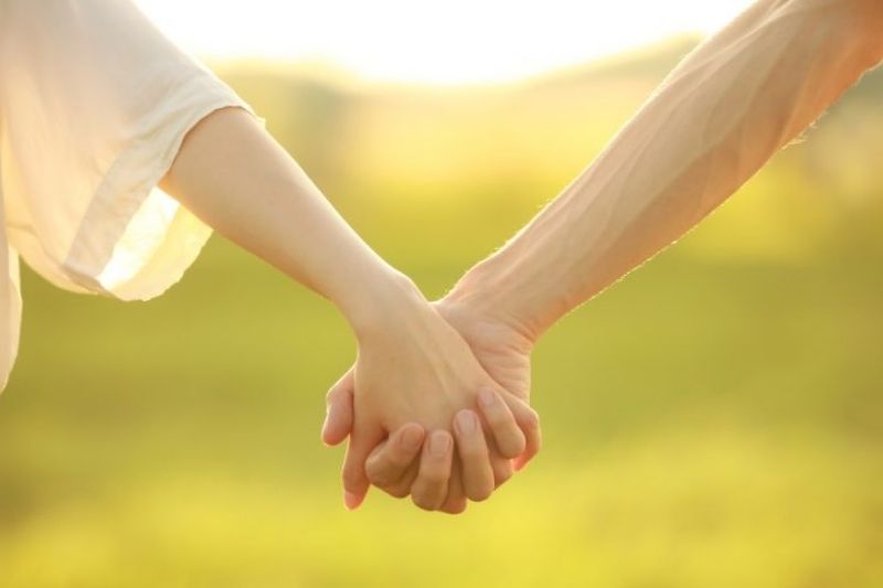 hai bàn tay nắm lấy nhau trong ánh sáng nhẹ