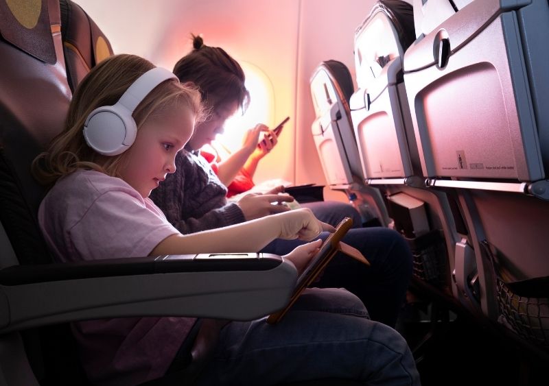 Trẻ nhỏ tô màu bằng sách hoạt động khi đang ngồi trên máy bay