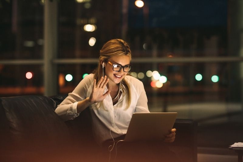 Phụ nữ trò chuyện video với bạn bè buổi tối, ánh sáng ấm áp