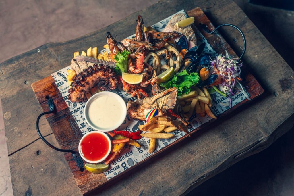 Bàn tiệc hải sản Creole tại Seychelles bên bãi biển hoàng hôn
