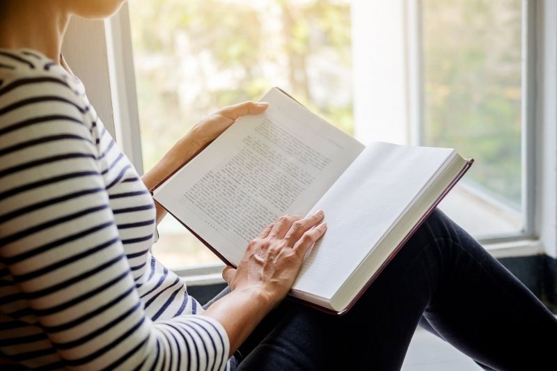 Cha mẹ đọc sách bên cửa sổ trong tháng sống chậm