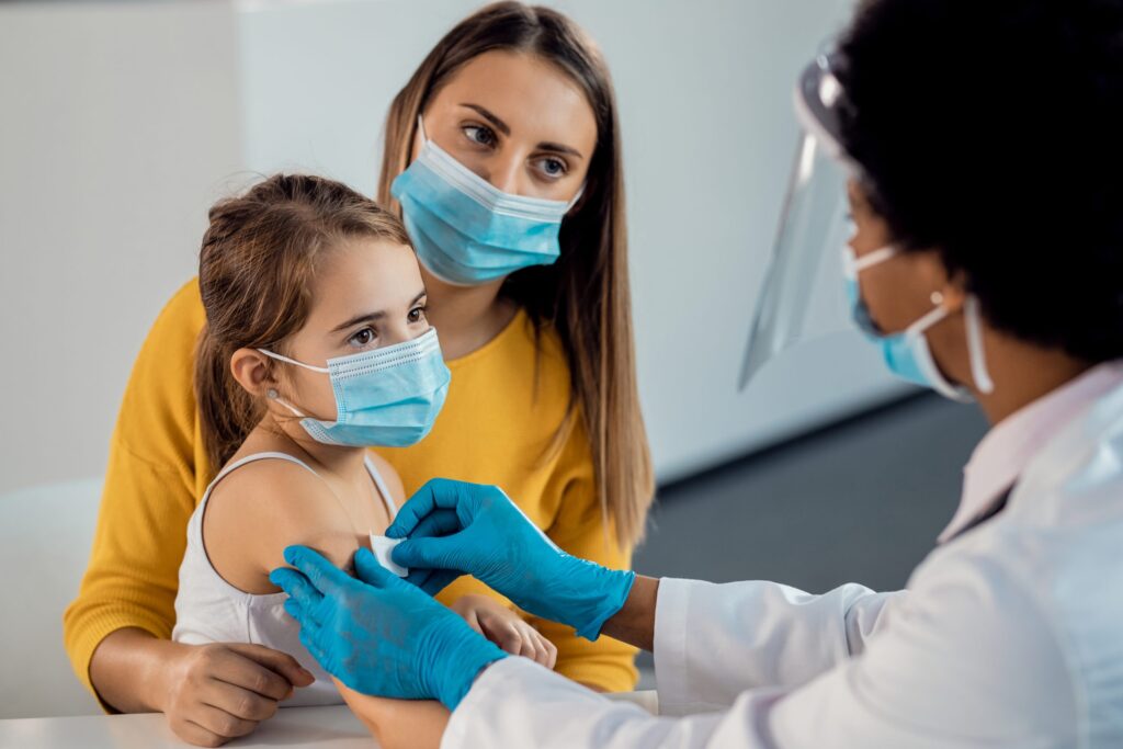 Trẻ em được bác sĩ tiêm vaccine tại phòng khám