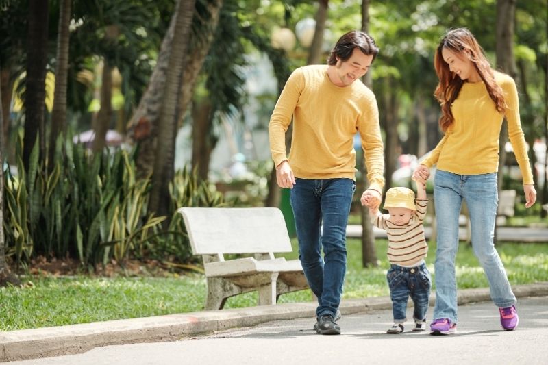 Cha mẹ dắt con đi dạo công viên