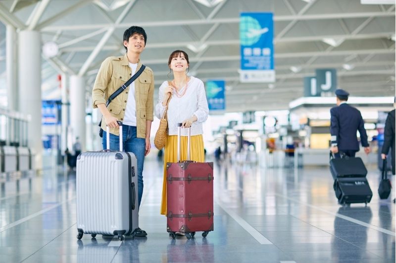 cặp đôi kéo vali sang trọng trong chuyến trăng mật
