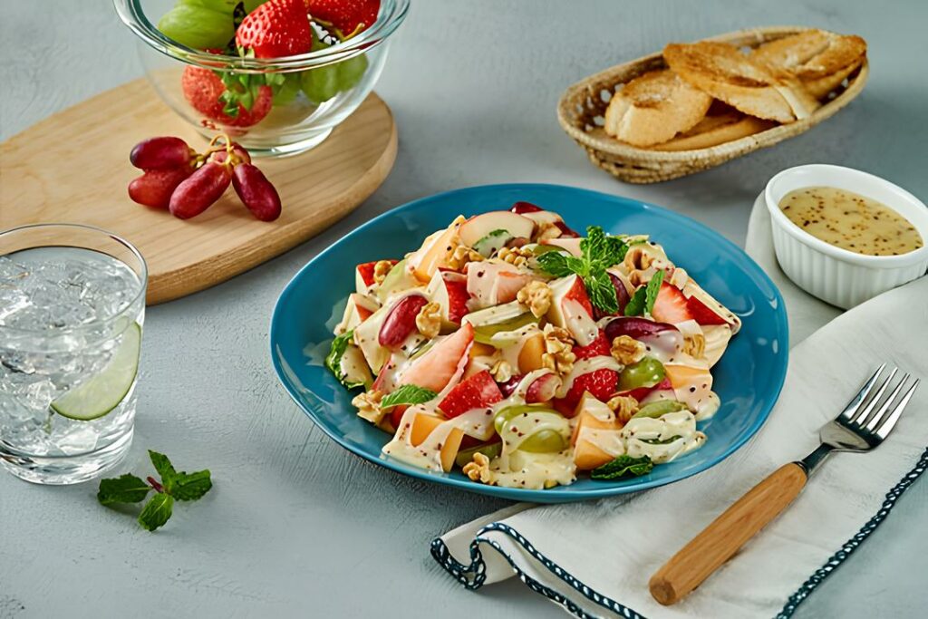 Bàn ăn với salad, trái cây tươi và chai nước.