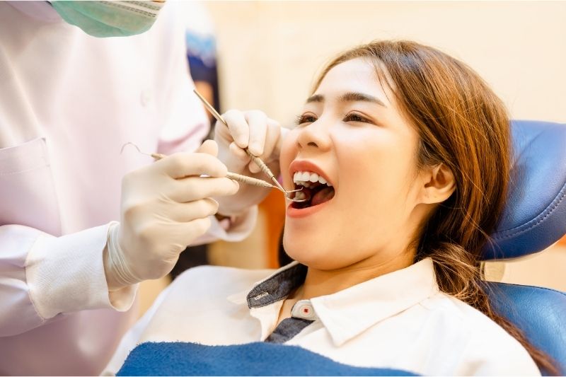 Nha sĩ kiểm tra răng cho bệnh nhân trong phòng khám hiện đại.