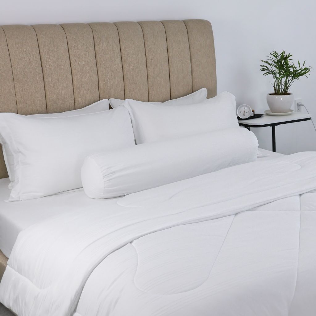 Ga giường cotton trắng và gối lụa mềm.
