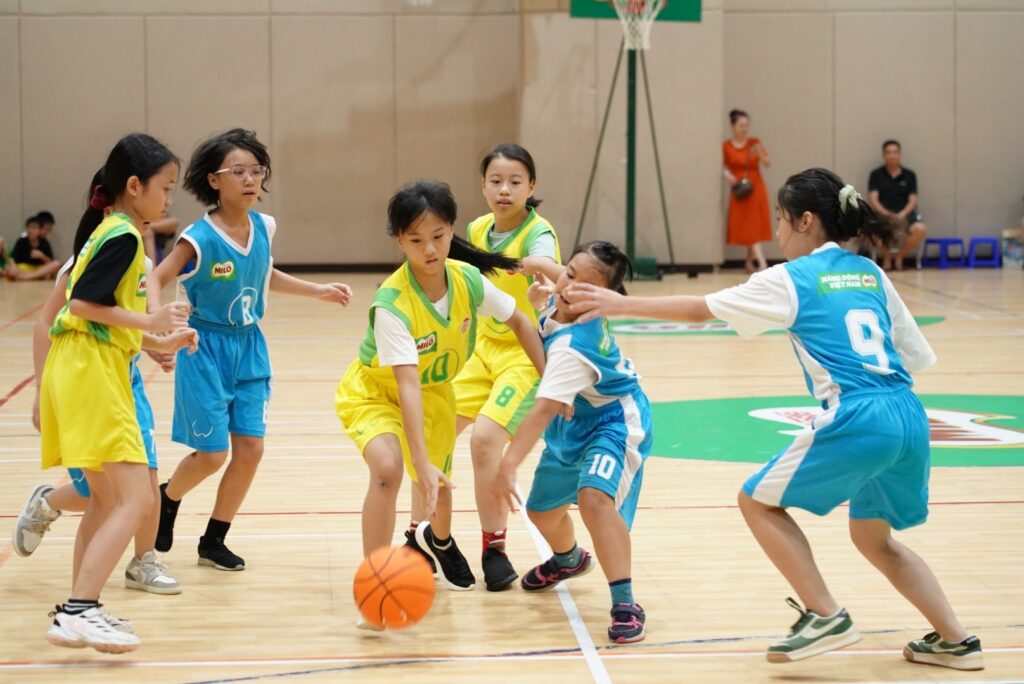Nhóm học sinh tuổi dậy thì chơi bóng rổ trong trường