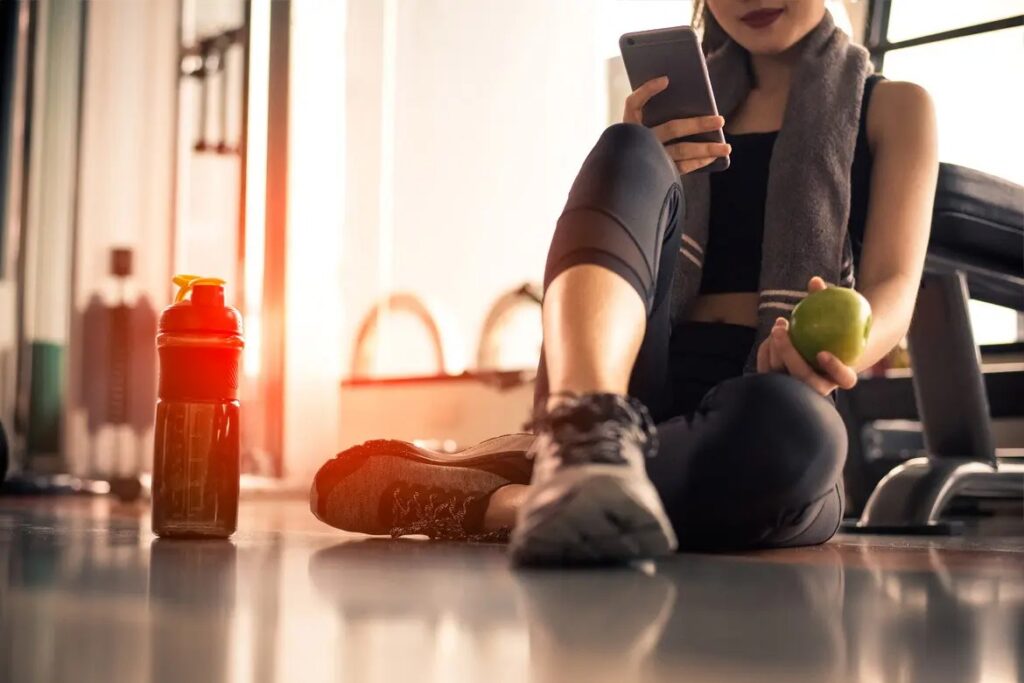 Người trẻ ngồi thư giãn sau buổi tập luyện trong phòng gym